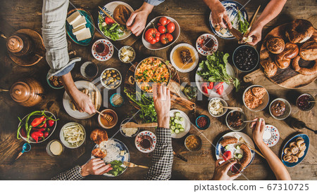 Flat-lay of Turkish breakfast and family eating Flat-lay of Turkish breakfast and family eating 67310725
