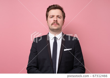Handsome young man in suit looking at camera serious and confident. 67312466