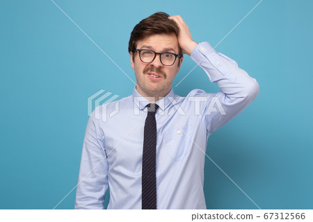Young businessman puzzled trying to make a hard decision 67312566