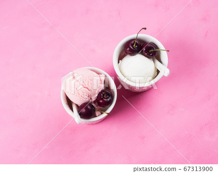 Two ice cream cups with cherries on pink 67313900