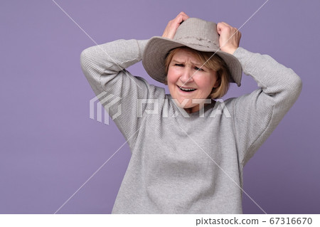 Funny senior caucasian woman remembered something and holds a hand on head 67316670