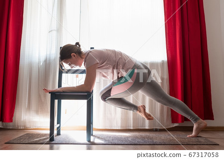 Woman doing push ups exercises for training chest and arms muscles at home 67317058