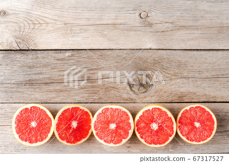 Grapefruit halves on wooden background with copyspace 67317527