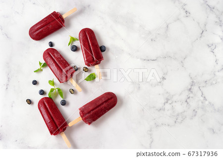 Refreshing blueberries sorbet popsicles on white Refreshing blueberries sorbet popsicles on white 67317936