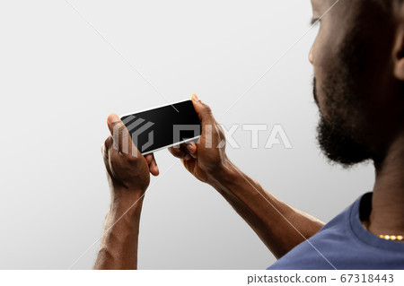 Close up male hands holding smartphone with blank screen during online watching of popular sport matches and championships all around the world. Copyspace for ad Close up male hands holding smartphone with blank screen during online watching of popular sport matches and championships all around the world. Copyspace for ad 67318443