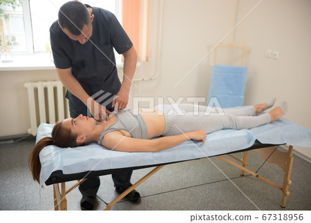 Young woman having osteopathic treatment in the clinic with professional doctor Young woman having osteopathic treatment in the clinic with professional doctor 67318956