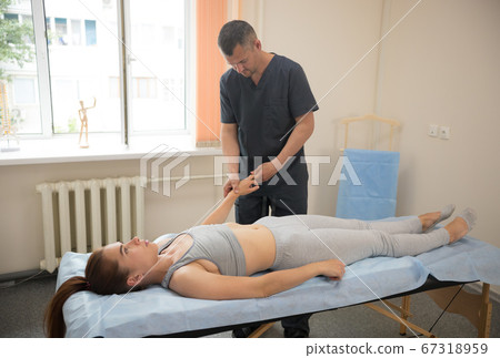 Young woman having osteopathy treatment - doctor massaging her fingers Young woman having osteopathy treatment - doctor massaging her fingers 67318959