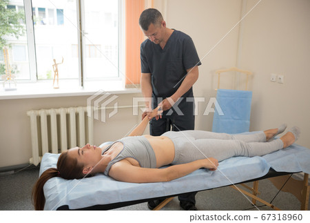 Young woman having osteopathy treatment indoors - doctor massaging her fingers Young woman having osteopathy treatment indoors - doctor massaging her fingers 67318960