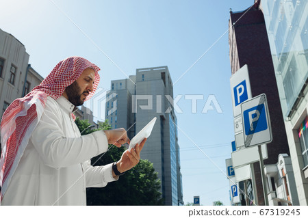Smiling rich arabian man's buying real estate in the city 67319245