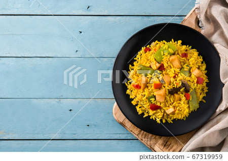 Fried rice with chicken and vegetables on black plate on blue wooden table. Copy space	 67319959