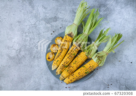 Grilled sweet corn cobs with herbs, salt and spices Grilled sweet corn cobs with herbs, salt and spices 67320308