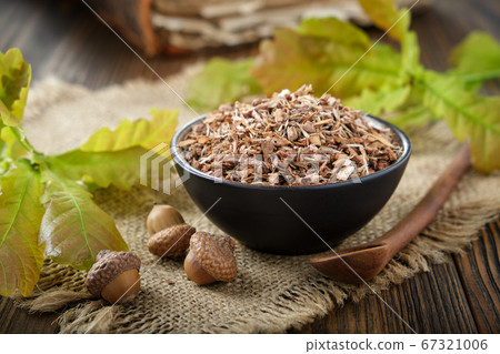 Oak bark in black ceramic bowl and acorns Oak bark in black ceramic bowl and acorns 67321006