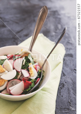 Vegetable vegan salad of ramson, radish, green onions and boiled eggs with yoghurt dressing in a 67321557