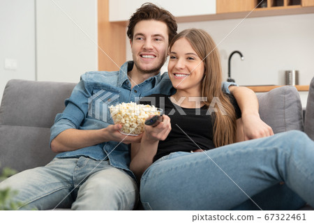 Young couple watching TV on sofa 67322461