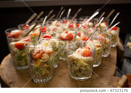 Fresh salad in glasses. Starter appetizer table. Banquet or event in cafe. Holiday or event treats. Catering food concept Fresh salad in glasses. Starter appetizer table. Banquet or event in cafe. Holiday or event treats. Catering food concept 67323176