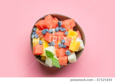 Healthy breakfast banana and blueberry smoothie decorated fruits in coconut bowl on pink. Healthy breakfast banana and blueberry smoothie decorated fruits in coconut bowl on pink. 67325893