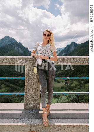 attractive woman traveller relax in mountains and holding coffee mug attractive woman traveller relax in mountains and holding coffee mug 67326041