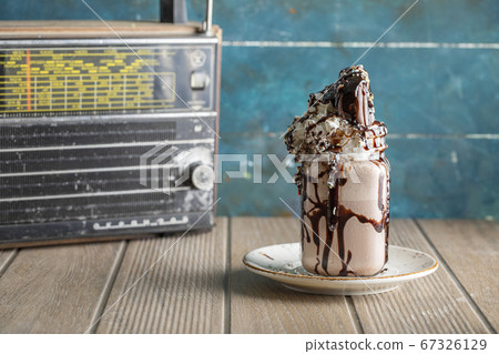 Creamy vanilla milky shake with chocolate sauce in a white saucer Creamy vanilla milky shake with chocolate sauce in a white saucer 67326129