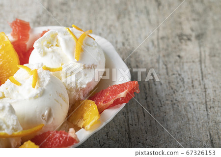 Vanilla icecream with watermelon and orange fruit pieces 67326153