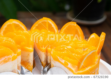 a lot of real orange cake wrap by foil and plastic on white plate and wood table stock photo 67328190
