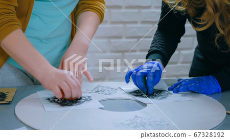 Women decorators, designers painting wooden circle decoration 67328192