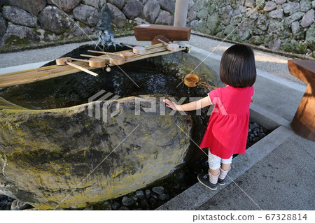 穿著紅色衣服的女孩在神社的水房淨化雙手 穿著紅色衣服的女孩在神社的水房淨化雙手 67328814