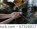 Hands of a child washing out by holding a dipper in the waterhouse 67328817