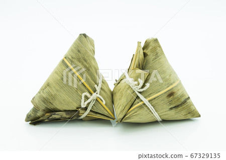 Closeup view of the zongzi (sticky rice dumplings), it is a traditional Chinese rice dish made of glutinous rice stuffed with different fillings and wrapped in reed leaves. Closeup view of the zongzi (sticky rice dumplings), it is a traditional Chinese rice dish made of glutinous rice stuffed with different fillings and wrapped in reed leaves. 67329135
