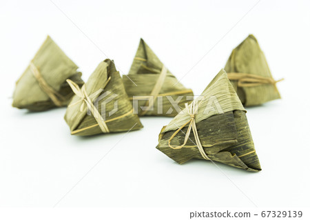 Closeup view of the zongzi (sticky rice dumplings), it is a traditional Chinese rice dish made of glutinous rice stuffed with different fillings and wrapped in reed leaves. Closeup view of the zongzi (sticky rice dumplings), it is a traditional Chinese rice dish made of glutinous rice stuffed with different fillings and wrapped in reed leaves. 67329139