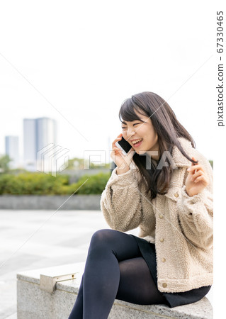 A woman touching a smartphone 67330465