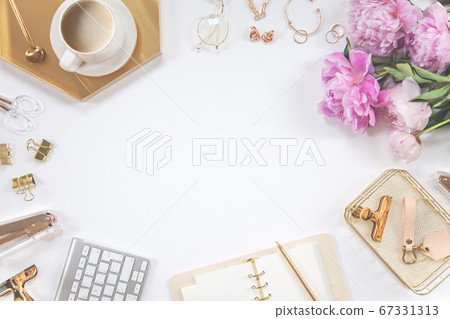 Frame of gold stationery on a white background. Diary, calculator, coffee mug, stapler, hole punch, pen, glasses and keyboard. Frame of gold stationery on a white background. Diary, calculator, coffee mug, stapler, hole punch, pen, glasses and keyboard. 67331313