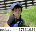 Boy crouching in the garden and staring at something 67331984