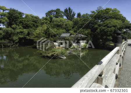 An early summer landscape where you can see the former Kujo Family Garden in Kyoto Gyoen, Itsukushima Shrine on the island in Kujo Pond and Takakura Bridge over the pond 67332301