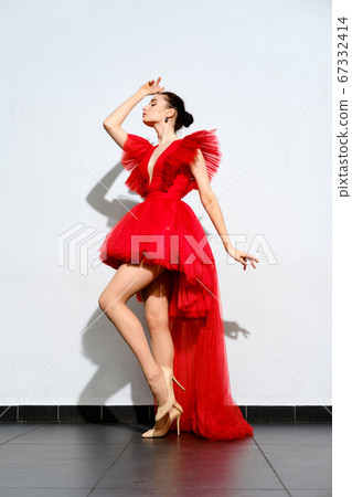 girl in short red tulle dress with long tail 67332414