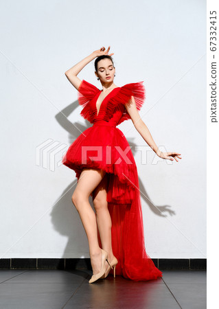 girl in short red tulle dress with long tail girl in short red tulle dress with long tail 67332415