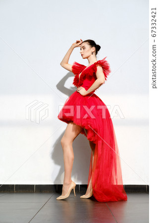 girl in short red tulle dress with long tail 67332421