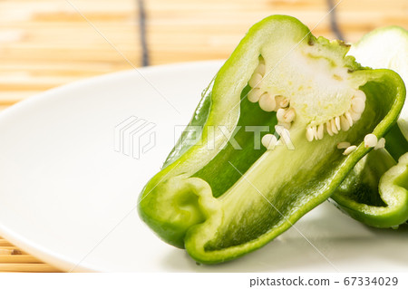 青椒的橫截面垂直切成兩半。背景，百葉窗。 67334029