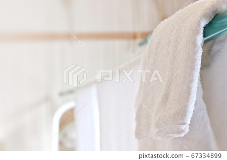 洗滌後,桿子上的干毛巾在室內乾燥 洗滌後,桿子上的干毛巾在室內乾燥 67334899