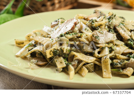 Tagliatelle pasta with spinach and mushrooms on a Tagliatelle pasta with spinach and mushrooms on a 67337704