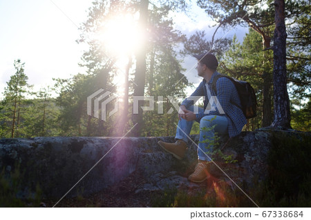 man stopping for rest on countryside walk sitting alone 67338684