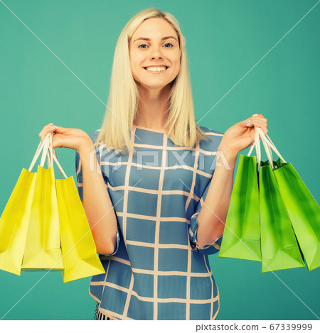 Happy girl in a checkered blouse holds shopping Happy girl in a checkered blouse holds shopping 67339999
