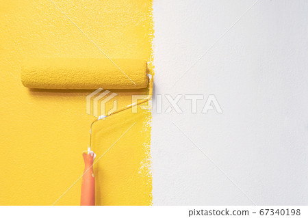 The painter is painting the yellow wall room. The painter is painting the yellow wall room. 67340198