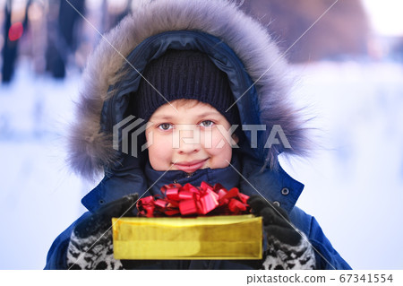 Happy boy with gift box outdoors 67341554