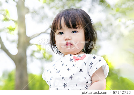 凝視新鮮的綠樹背景的女孩 凝視新鮮的綠樹背景的女孩 67342733