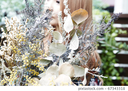 捲髮的女人和植物上乾花和花裙子的照像照片 67343318
