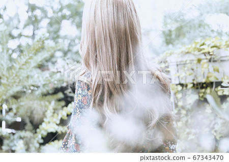 美麗的頭髮捲髮女人和植物背景上鏡的照片 美麗的頭髮捲髮女人和植物背景上鏡的照片 67343470