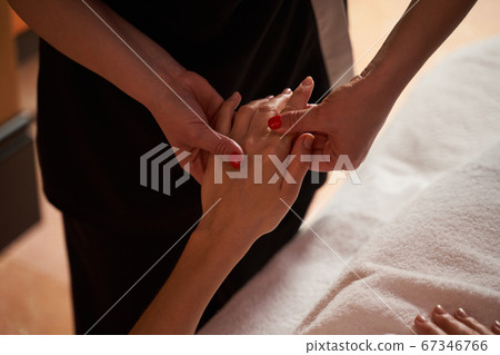 Soft touch of massage therapist during the pleasant spa treatment 67346766