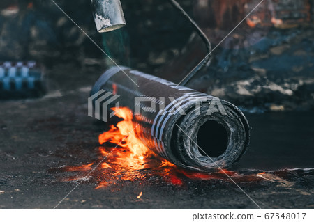 Roll roofing Installation with propane blowtorch during construction works 67348017