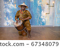 Handsome african drummer weared in traditional costume playing on djembe drum 67348079