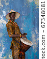 African man in traditional clothes playing djembe drum 67348081